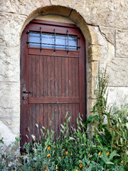 Old brown wooden door on stone wall