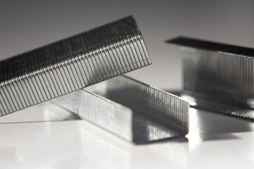 Stapler standing in a row isolated on white background. Staple on top is selective focused.