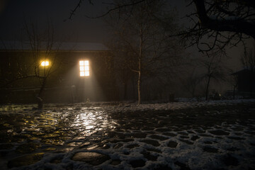 wooden house in winter forest. Mountain house in the snow at night. Misty night.