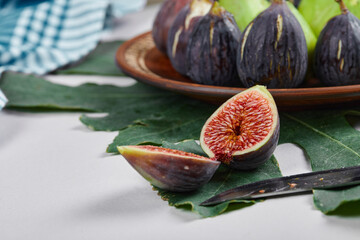 Green and purple figs in a wooden platter