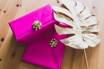 couple of birthday present wrapped up in pink and gold on wooden table, parties and celebrations