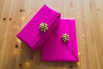 couple of birthday present wrapped up in pink and gold on wooden table, parties and celebrations