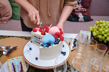 Pregnant woman cuts the cake into gender party to determine the sex of the baby, boy or girl