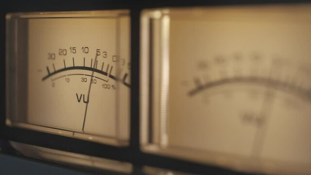 Audio signal levels monitoring audio console on classic sound amplifier. Close-up analog signal indicator with arrow