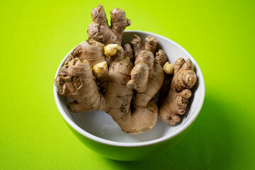 Fresh ginger root on green background