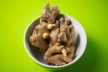 Fresh ginger root on green background