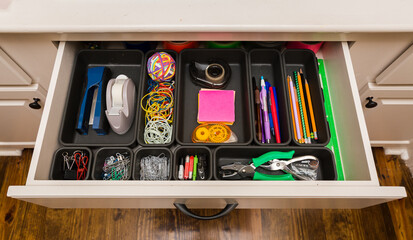 Organized desk drawer with office supplies in bins - obrazy, fototapety, plakaty