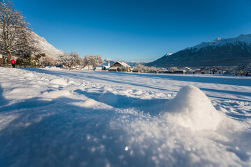 Idyllic winter landscape in small village with sparkling blurred snow piles in Austrian alps, Wildermieming, Tirol, Austria