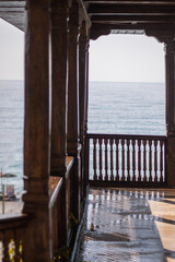 View from the balcony at the sea. Wet old-style wooden balcony.