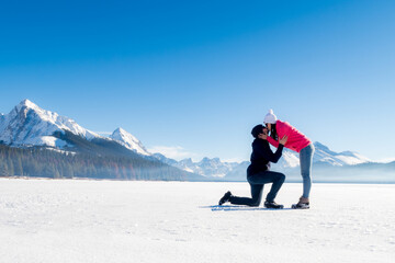 Winter view of a young couple kissing at Maligne Lake in Jasper National Park, Canada