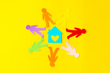 Diversity, inclusion, adoption concept. Colorful paper cut figure on yellow background.