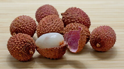 Several lychee fruits, one with open peel
