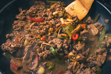 Steak peppers and onions being fried in a pan