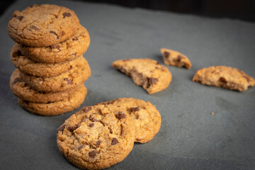 freshly baked Chocolate chip cookies on a dark stone with place for text. Copy space.