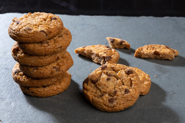 freshly baked Chocolate chip cookies on a dark stone with place for text. Copy space.