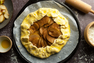 Cooking rustic pie, galette, with pears and cinnamon. Cooking healthy dessert. Top view.