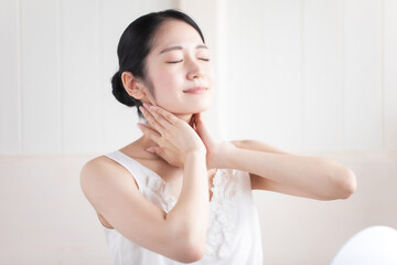 首を触る女性（笑顔）
