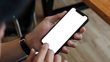 Obraz premium Cropped shot view of man hands holding smart phone with blank copy space screen for your text message or information content, female reading text message on cell telephone during in urban setting.
