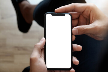 Cropped shot top view of businessman hands using smartphone mockup at the white office desk. Blank screen mobile phone for graphic display montage