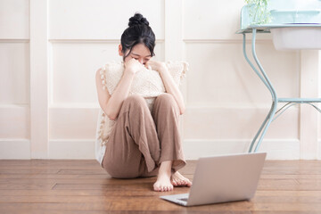 部屋でノートパソコンを使う女性
