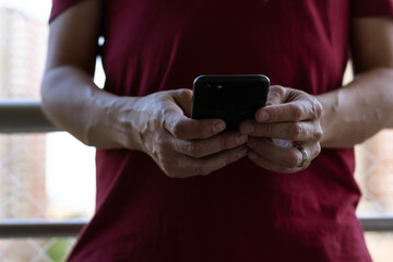 Man's hand with cell phone on balcony