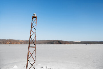 small lighthouse on metal table for small islands without people, online management, winter landscape of the frozen sea, selective focus
