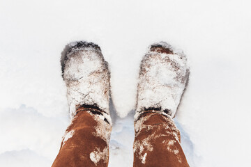 Brown boots covered with snow in the winter