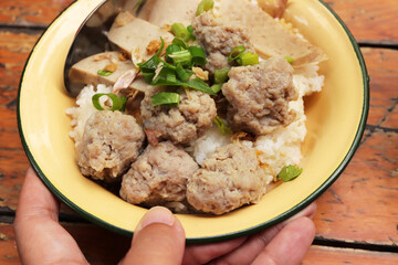 Dried Rice with pork and steamed pork sausage in yellow zinc bowl. Asian breakfast style.
