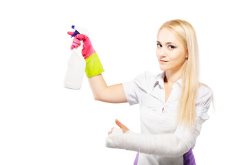 Girl with broken arm in plaster, holding cleaning product