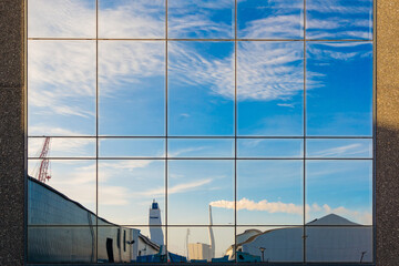 Reflection Of An Industrial Plant In A Glass Front