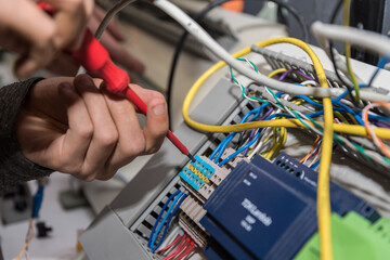 Electrician Works With A Screwdriver At Power Connections