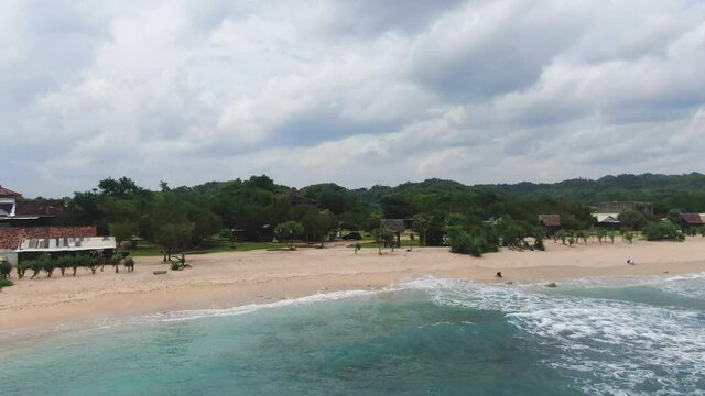 Aerial panorama of scenic Krakal coast with golden sand beach and volcanic cliff