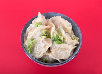 A bowl of dumplings on a red background