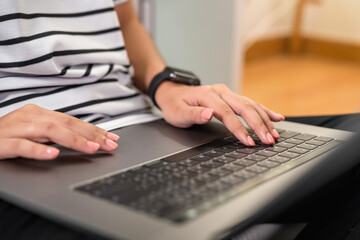 Hand using digital laptop on the table in office and wear smartwatch.