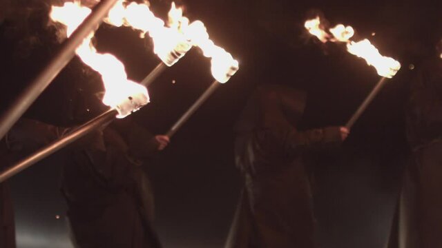 - men in black with torches, procession, rite