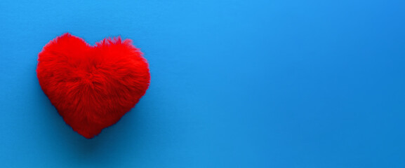 .Heart. One fluffy red heart lies on a blue background. Valentine's day and Birthday. Banner, copy space