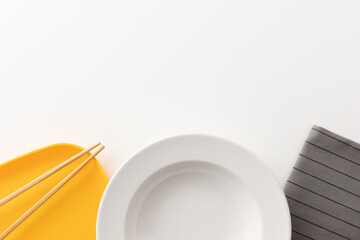 Kitchen sets, plates, napkins and chopsticks are placed together on a white table.