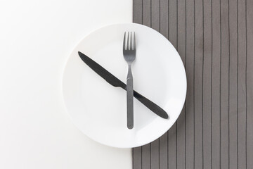 White empty plates set on the table with knives and forks and tablecloths. Ready to eat