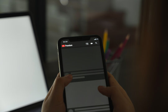 BANGKOK, THAILAND - January 25, 2021 : Woman holding smartphone and show screen YouTube premium video service.