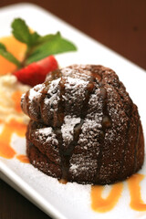 Warm Chocolate Lava Cake with Bite Taken Out of Molten Center and Red Currants on Vintage Metal Plate