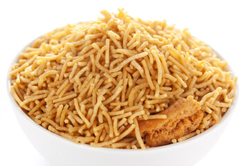 Indian spicy snacks (Namkeen) - Bikaneri Besan Bhujia in a white bowl, made with chickpea flour (Besan), side view, against the white background.