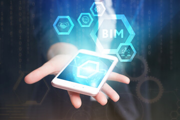 Business, Technology, Internet and network concept. Young businessman working on a virtual screen of the future and sees the inscription: BIM