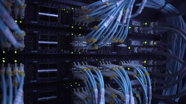 Fiber Optic cables connected to optic ports. Big data center