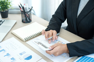 The businesswoman hand sits at their desks and calculates financial graphs showing the results of their investments planning the process of successful business growth