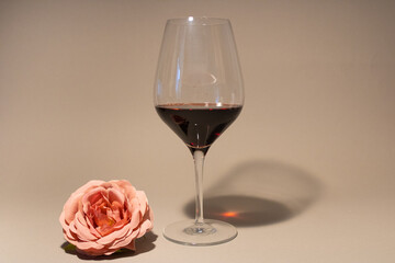 Glass of black vine with pink flower.