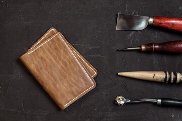 handmade leather wallet with tools from the workshop. genuine leather accessory