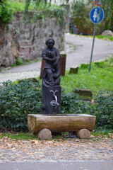 Freiburg im Breisgau, Germany - 11 01 2012: A outdoor tap with drinking water with wooden statue of a boy with a fish in the park 