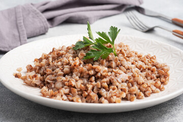Boiled buckwheat on a plate. Healthy porridge enriched with vitamins.