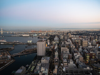 日本の横浜の風景。夕暮れの海と街と工場地帯の風景。
