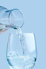 Pouring water. pouring drinking water from a glass decanter to glass.